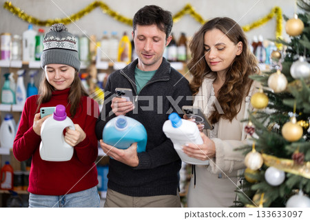 Family scanning barcode on detergent bottles in Christmas decorated store 133633097