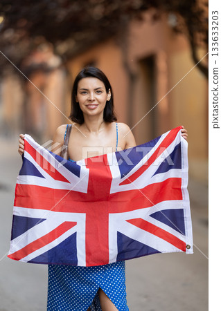 Young woman with UK flag on city street Young woman with UK flag on city street 133633203