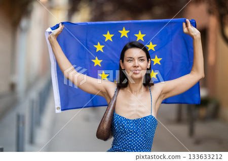 Girl waving European Union flag on street of summer city Girl waving European Union flag on street of summer city 133633212