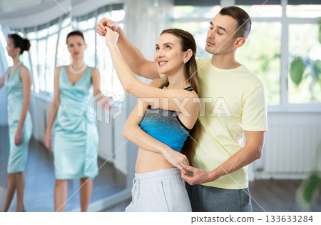 Couple in comfortable sports clothes waltz dancing during individual lesson 133633284