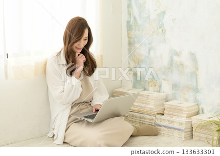 一位女士正看著放在腿上的筆記型電腦。 一位女士正看著放在腿上的筆記型電腦。 133633301