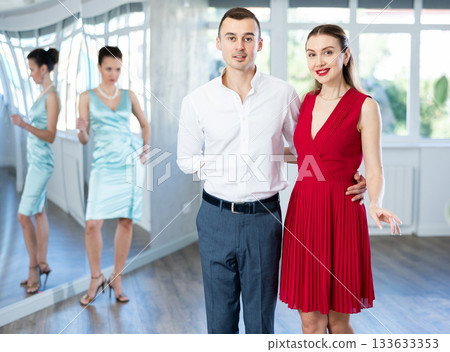 Couple in formal wear rehearsing wedding waltz in dance studio Couple in formal wear rehearsing wedding waltz in dance studio 133633353