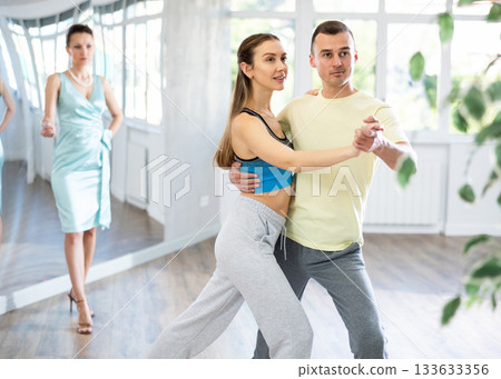 Couple in comfortable sports clothes waltz dancing during individual lesson 133633356