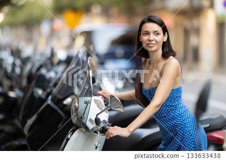 Young woman rents bike on city street 133633438