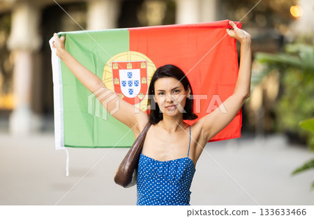 Young woman with portuguese flag on city street 133633466