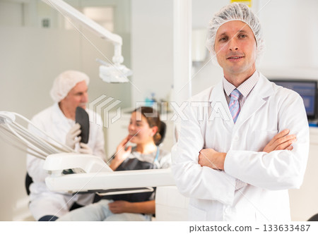 Man doctor dentist is standing in dental office, clinic Man doctor dentist is standing in dental office, clinic 133633487
