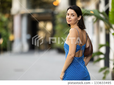Young brunette girl in blue dress walking along the streets of the historical center of city Young brunette girl in blue dress walking along the streets of the historical center of city 133633495