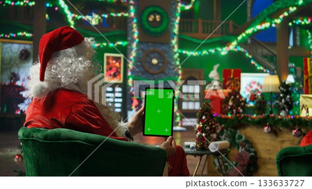 Santa Claus responding to kids requesting gifts, typing on isolated screen tablet. Person impersonating Santa Claus asking children what they want for Christmas using mockup device, camera A 133633727
