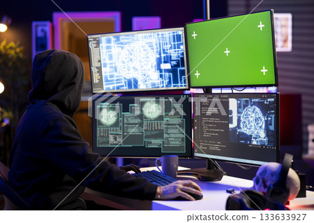 Rogue programmer uses AI on isolated screen PC to develop malware undetectable by antivirus. Hooded hacker uses chroma key computer and artificial intelligence to build script doing data mining 133633927