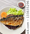 Steamed mackerel with soy sauce served over black rice, garnished with fresh vegetables and sesame seeds, healthy Asian meal. 133635296