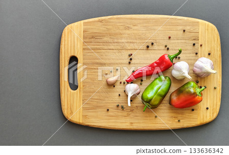 Pepper, chili, and garlic on a wooden surface. Top view. Pepper, chili, and garlic on a wooden surface. Top view. 133636342