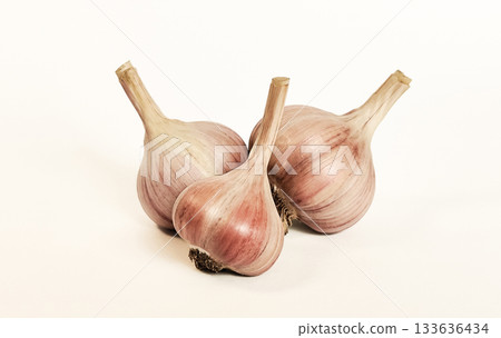 Three heads of garlic on a white background with a shadow. Isolate Three heads of garlic on a white background with a shadow. Isolate 133636434