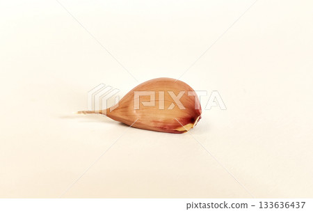 A clove of garlic on a white background with a shadow. Isolate 133636437