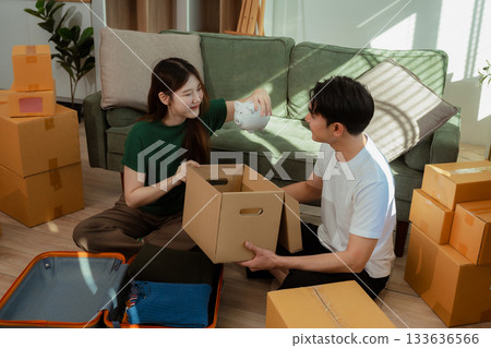 young couple helps put things in boxes and prepares to move to a new house. 133636566