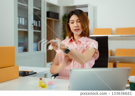 Asian vlogger woman influencer, SME retail store owner smile enjoy selling show live sale online screen smartphone and laptop work at home. 133636681