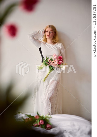 Stylish female model displaying flowers with artistic positioning Stylish female model displaying flowers with artistic positioning 133637281