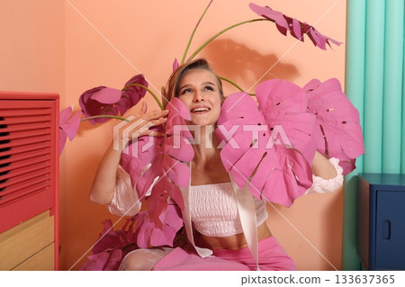 Woman radiates happiness among colorful tropical plant arrangement 133637365