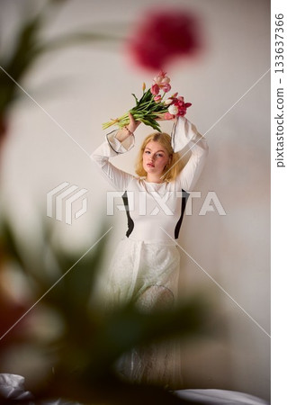 Blondehaired woman delicately balancing tulips with dreamy 133637366