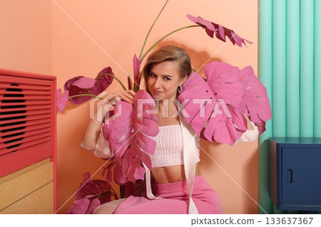 Young woman exudes confidence among bright floral leaves 133637367