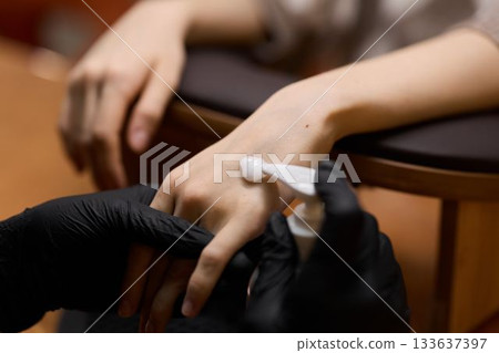Closeup of hygienic nail cleaning with sterile gloves and focused lighting Closeup of hygienic nail cleaning with sterile gloves and focused lighting 133637397