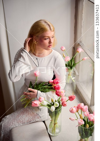 Quiet woman contemplates springtime blooms thoughtfully Quiet woman contemplates springtime blooms thoughtfully 133637413
