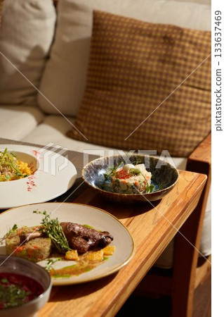 Indulge in an Elegant Dining Experience Featuring Gourmet Dishes Served on a Wooden Table 133637469