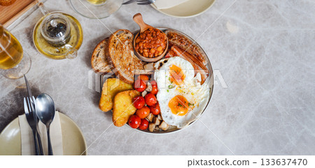 English breakfast menu fried eggs in grilled tomato and bacon sausage plate traditional tasty meal 133637470