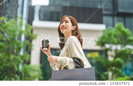 Single adult asian woman holding take away coffee cup and shopping bag city people lifestyle Single adult asian woman holding take away coffee cup and shopping bag city people lifestyle 133637471