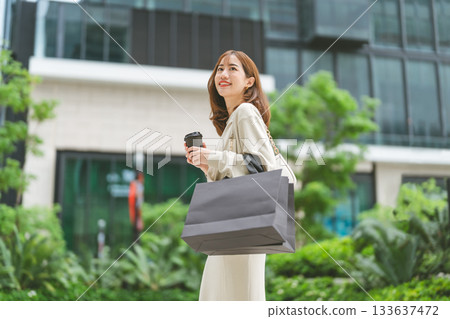 Single adult asian woman holding take away coffee cup and shopping bag city people lifestyle Single adult asian woman holding take away coffee cup and shopping bag city people lifestyle 133637472