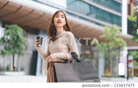 Single adult asian woman holding take away coffee cup and shopping bag city people lifestyle 133637475