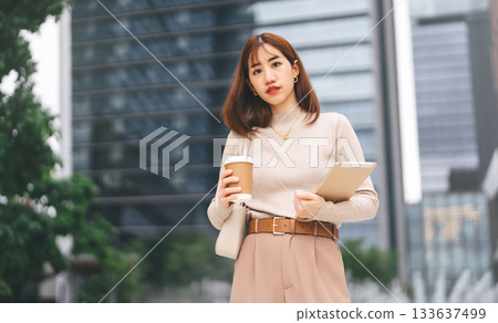 Happy smiling confidence business asian entrepreneur woman holding digital tablet and coffee cup 133637499