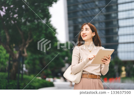 Happy smiling confidence business asian entrepreneur woman holding digital tablet and coffee cup Happy smiling confidence business asian entrepreneur woman holding digital tablet and coffee cup 133637500