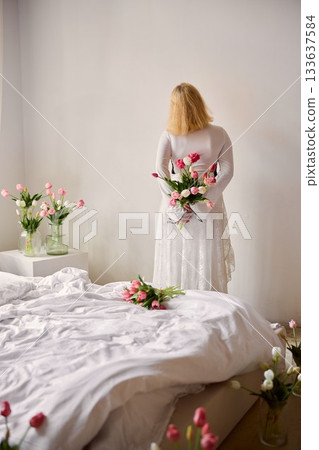 Peaceful scene featuring woman embracing bouquet of flowers Peaceful scene featuring woman embracing bouquet of flowers 133637584