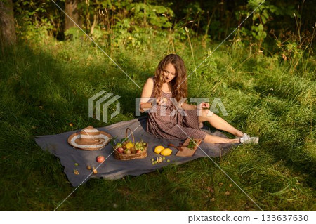 Relaxed female savoring peaceful tea amidst fresh fruit and sun 133637630
