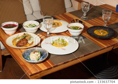 A Variety of Diverse Culinary Delights Arranged Elegantly on a Wooden Dining Table A Variety of Diverse Culinary Delights Arranged Elegantly on a Wooden Dining Table 133637704