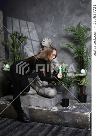 Female figure kneeling close to aged facade in urban sunset scene Female figure kneeling close to aged facade in urban sunset scene 133637721
