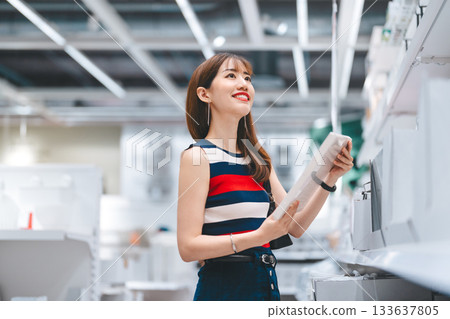 Adult asian woman choosing product home interior shopping buying new furniture at superstore 133637805