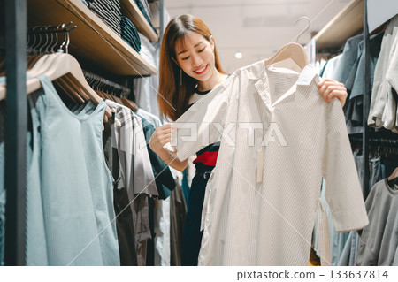 Happy asian woman shopping clothes in fashion shoping mall Happy asian woman shopping clothes in fashion shoping mall 133637814