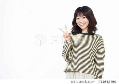 Smiling woman making a peace sign Smiling woman making a peace sign 133638160