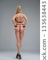 Woman poses in leather belts showcasing confidence and style in a studio setting 133638443