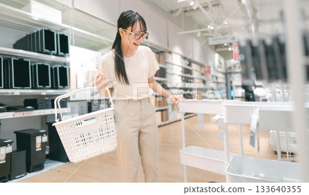Happy smiling asian woman with shopping basket choosing product for home japan furniture 133640355