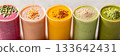 A rainbow of colored smoothies each topped with a small handful of buckwheat groats representing their ability to amp up the nutritional value of any smoothie 133642431
