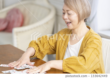 Senior women playing cards in the living room Senior women playing cards in the living room 133642449