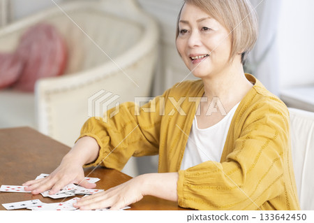 Senior women playing cards in the living room Senior women playing cards in the living room 133642450