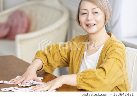 Senior women playing cards in the living room Senior women playing cards in the living room 133642451
