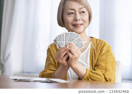 Senior women playing cards in the living room Senior women playing cards in the living room 133642468