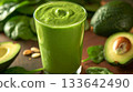 A fresh green smoothie made with spinach kale and avocado oil for added richness and health benefits 133642490