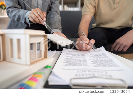 Real Estate Agent Assisting Client with Paperwork 133643064