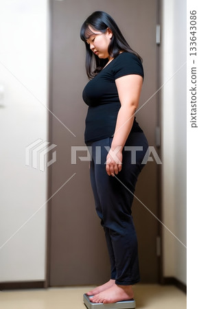 A woman with an anxious expression standing on a weight scale 133643086
