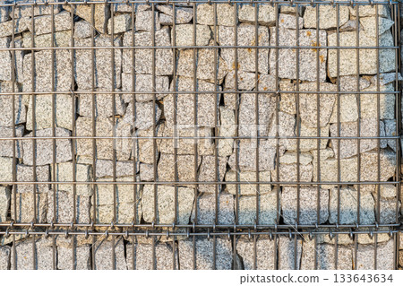 Modern Gabion Wall From Rocks And Stones In Metal Wire Box. Reinforcement and Abutment Protective Construction Modern Gabion Wall From Rocks And Stones In Metal Wire Box. Reinforcement and Abutment Protective Construction 133643634